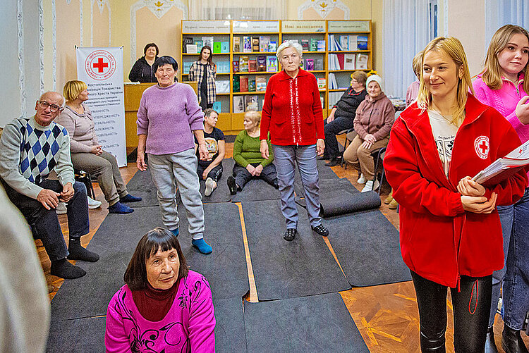 Senioren und Rotkreuzler in Gruppenraum