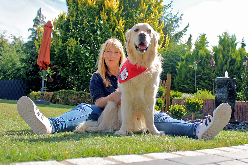 Petra Büssow und Milow auf einer Gartenwiese