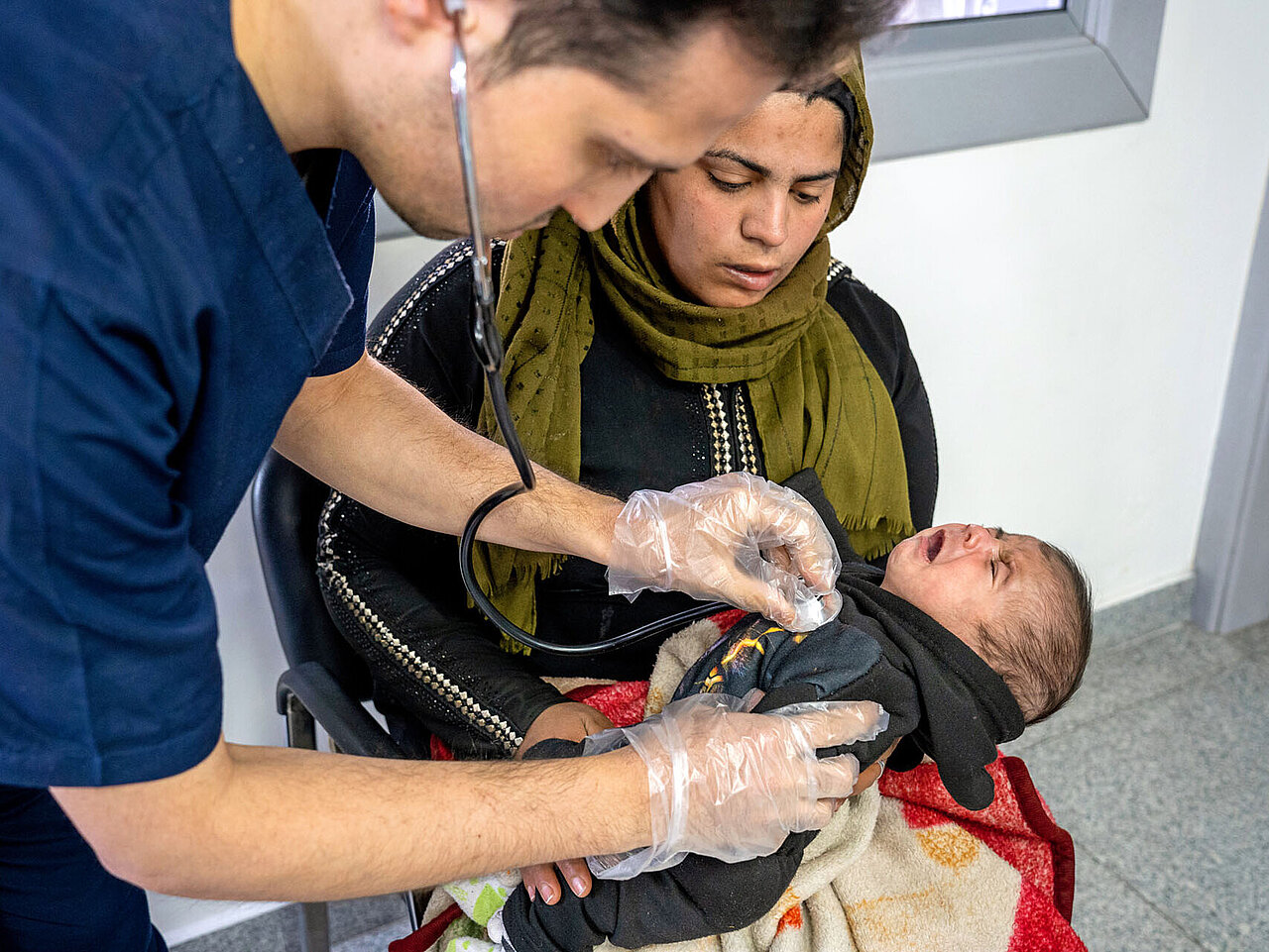 Arzt hört Baby ab in Armen der Mutter 