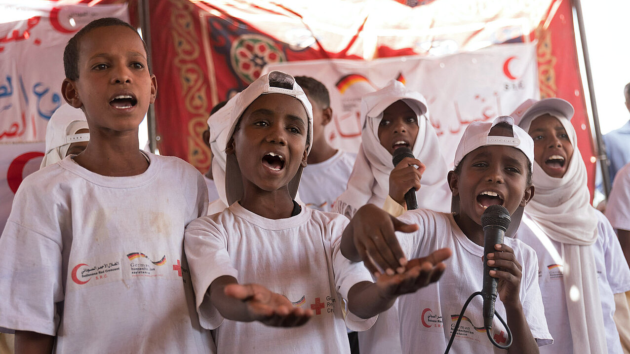 Kinder in weißen Projekt-Shirt singen