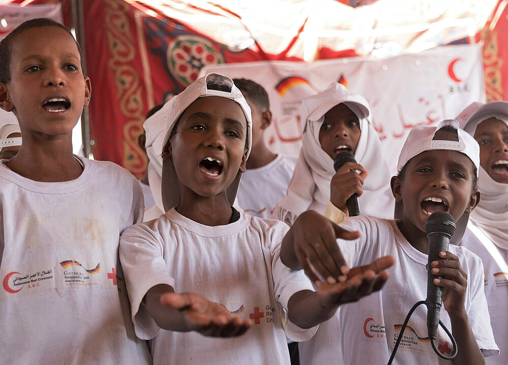 Kinder in weißen Projekt-Shirt singen