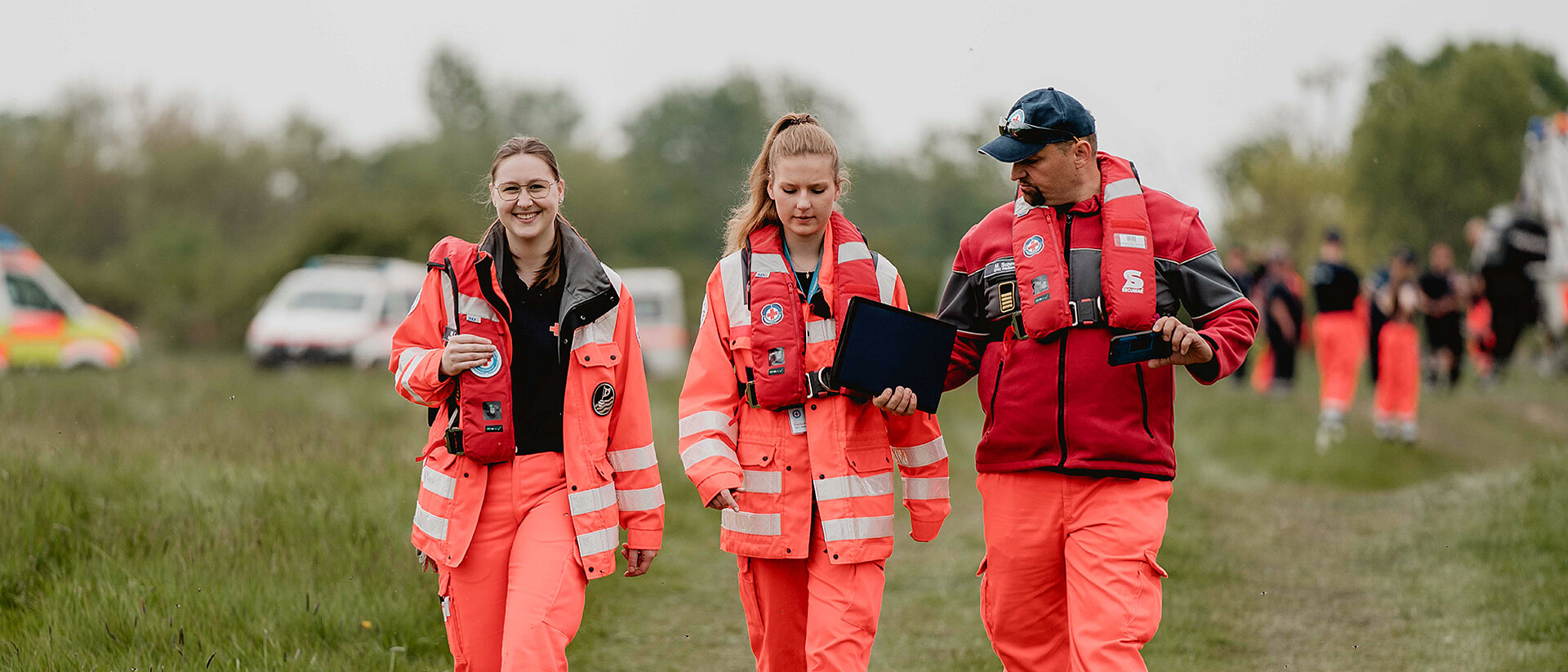 Drei Ehenamtliche laufen beim Unterhalten