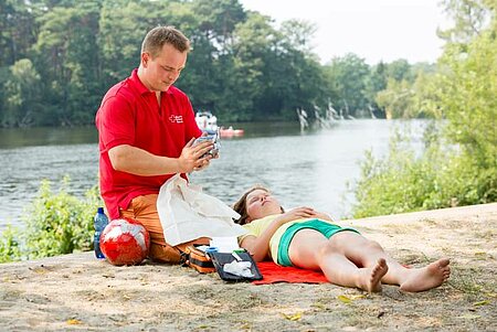 Ersthelfer mit Mädchen am Strand