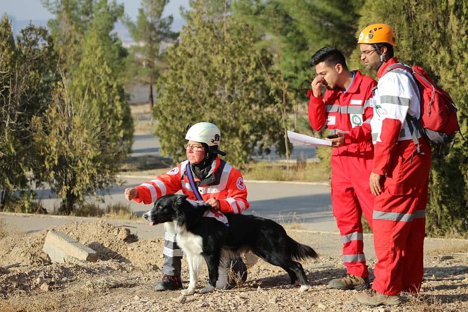 Eine DRK-Rettungshundeführerin und Iranische Kollegen mit einem Rettungshund im Einsatz