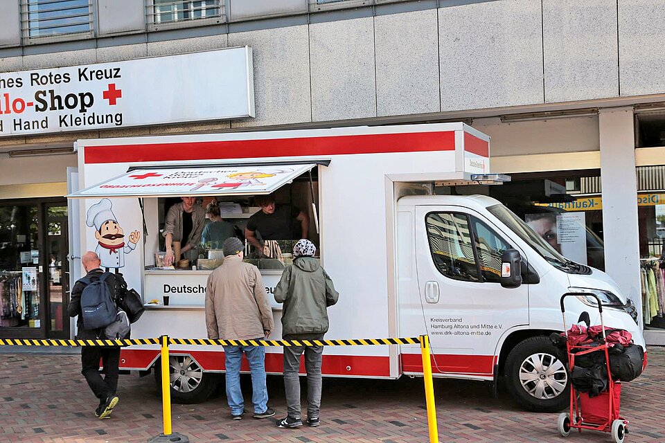 Kunden holen sich eine warme Mahlzeit beim Food Truck