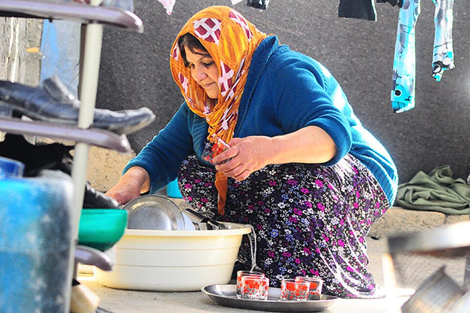Geflüchtete im Irak wäscht in Schüssel auf Boden ab