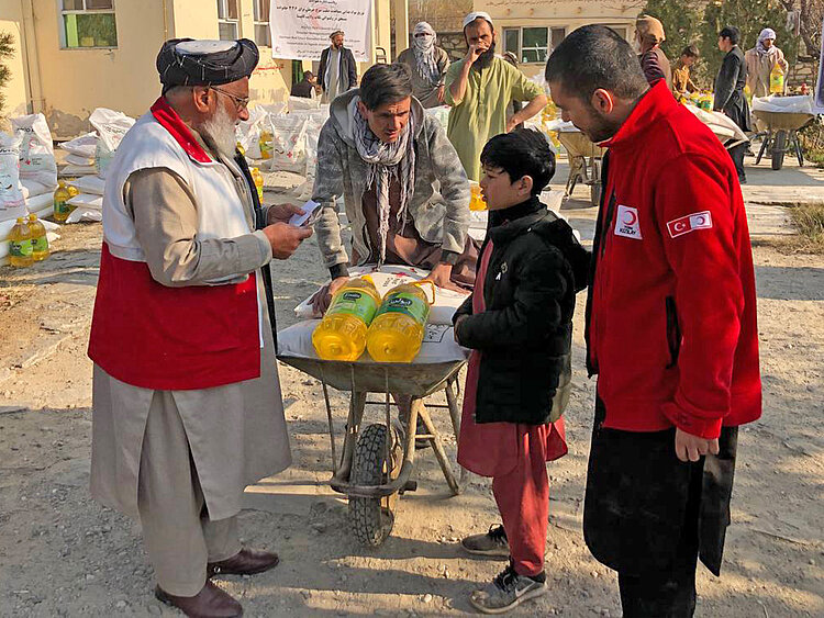 Verteilung von Lebensmittel-Paketen in Afghanistan mit Schubkarren