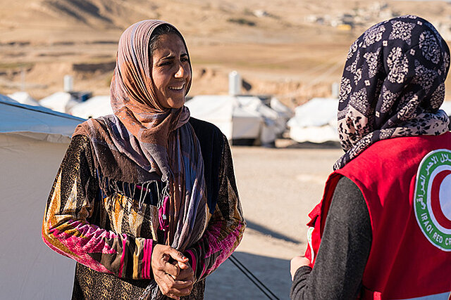 Frau im Irak spricht mit Helferin