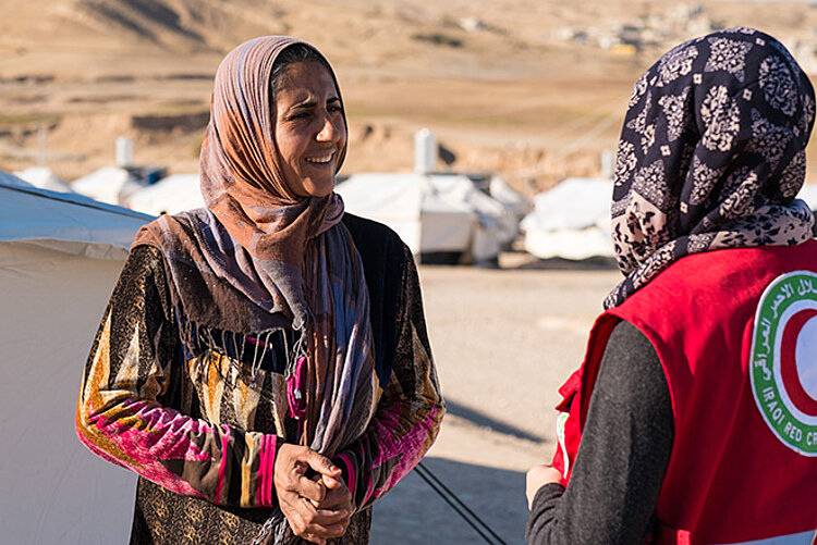 Frau im Irak spricht mit Helferin