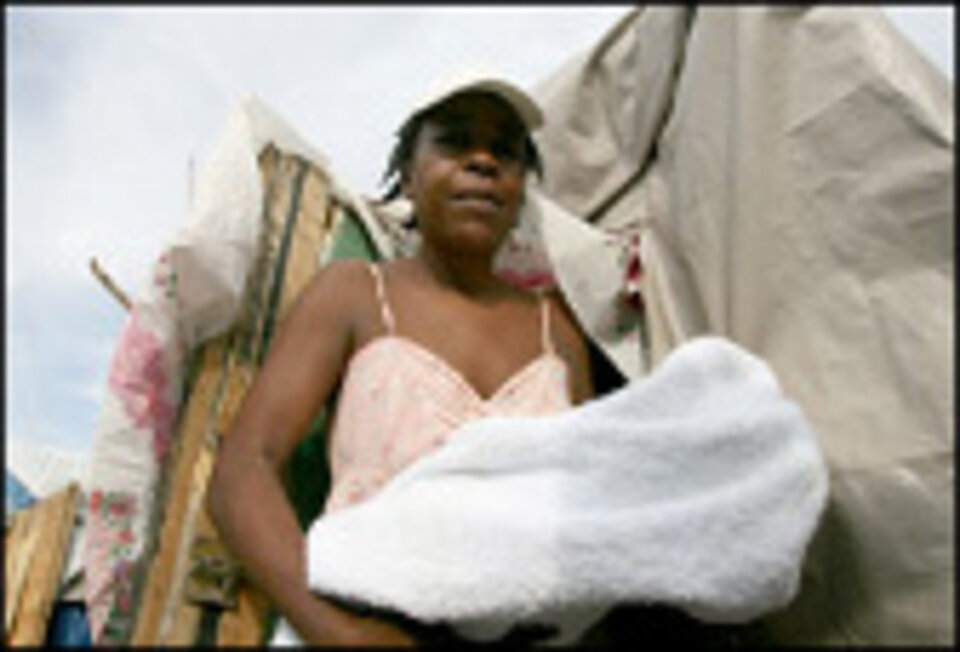 Foto: Marjorie Charles mit ihrem Töchterchen Ketuna vor ihrem Haus in L'Annexe de la Mairie, Cité Soleil, Port-au-Prince.