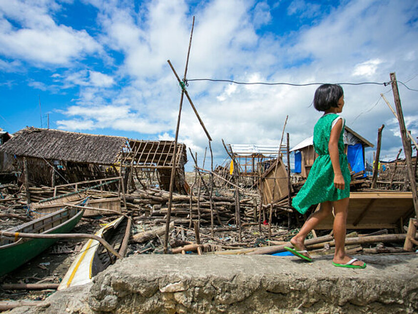 Foto: philippinisches Mädchen zwischen Trümmern nach Taifun Haiyan