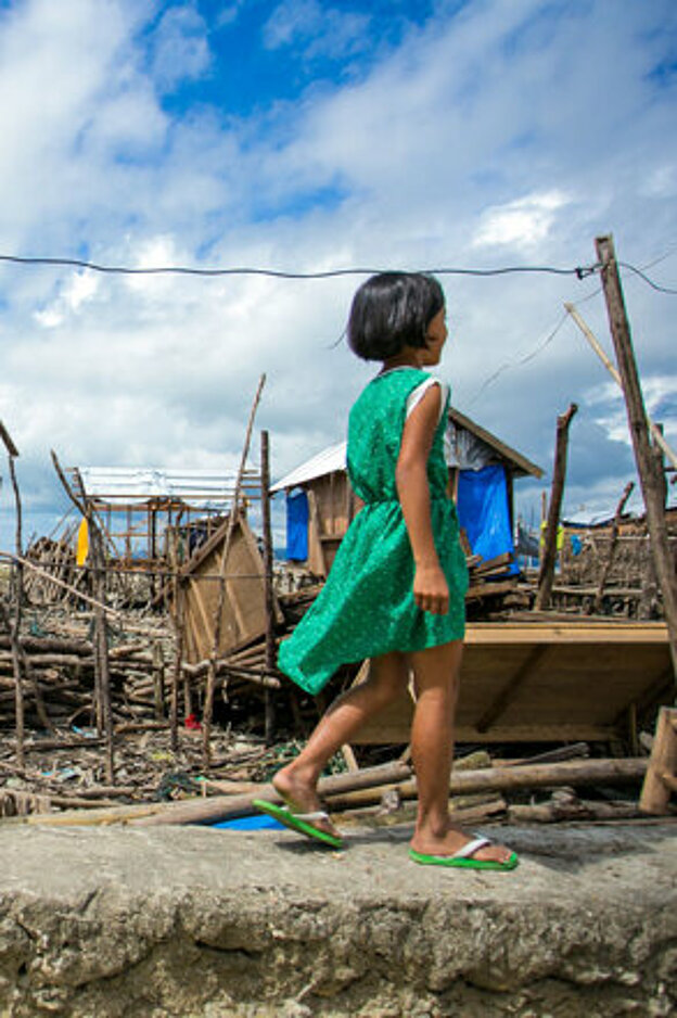Foto: philippinisches Mädchen zwischen Trümmern nach Taifun Haiyan