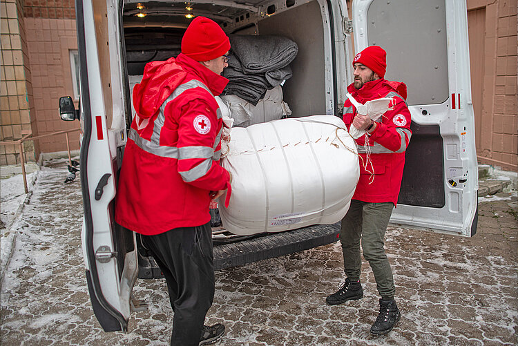 Rotkreuzhelfer verladen Güter für die Winterhilfe in der Ukraine 
