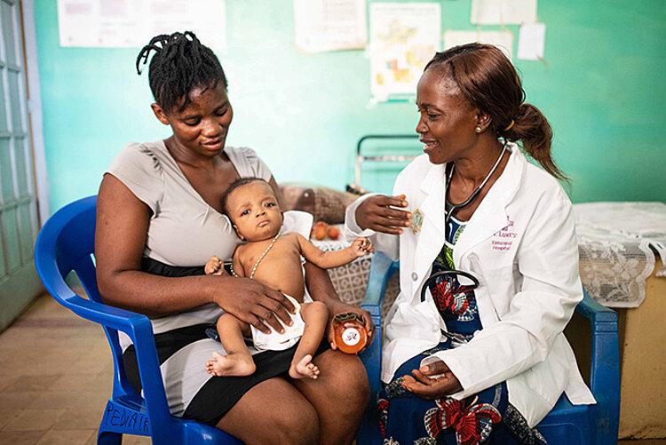 Foto: Kongolesische Kinerärztin mit einem Säugling und seiner Mutter zur Untersuchung auf Ebola