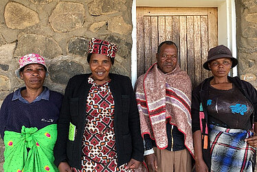 Vier Menschen in Lesotho mit teils traditioneller Kleidung