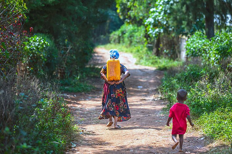 Frau trägt Wasserkanister