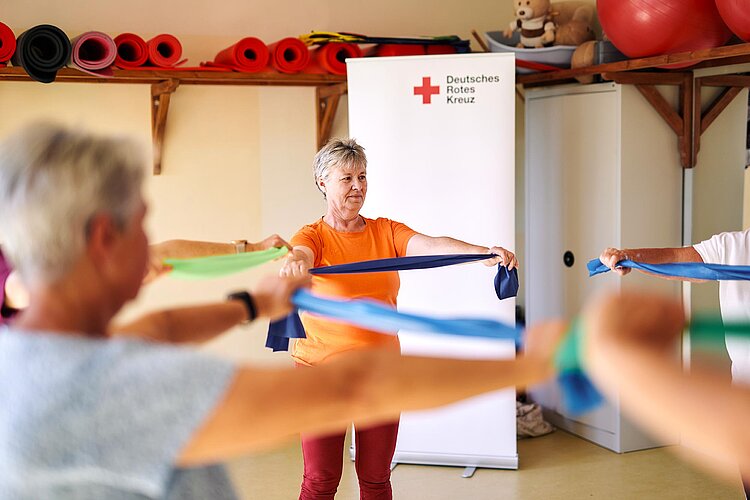 Gymnastik mit Theraband in Sportraum