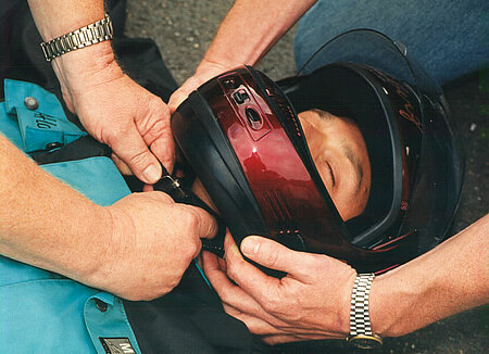 Kopf- und Nackenbereich beim Abnehmen des Helms stützen