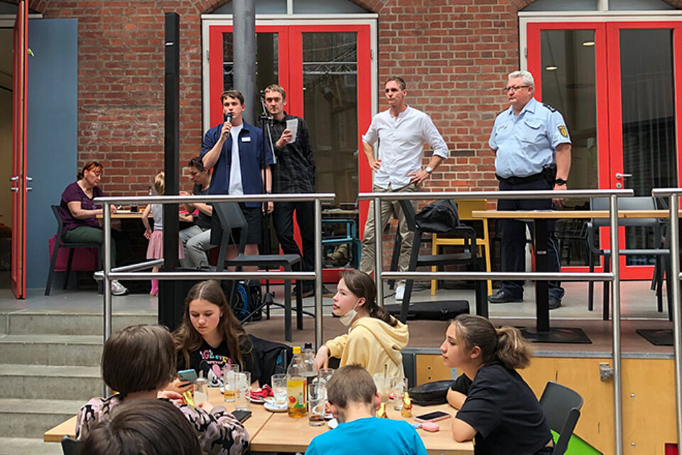 Männer auf der Bühne eines Café mit Mikrophonen