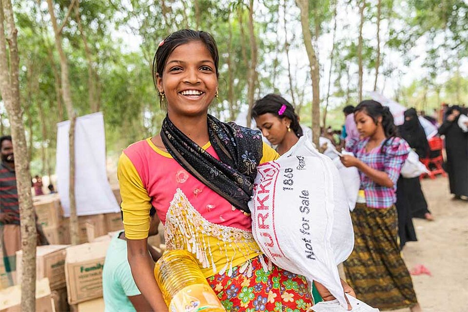 Frau aus Bangladesh hält Saatsack