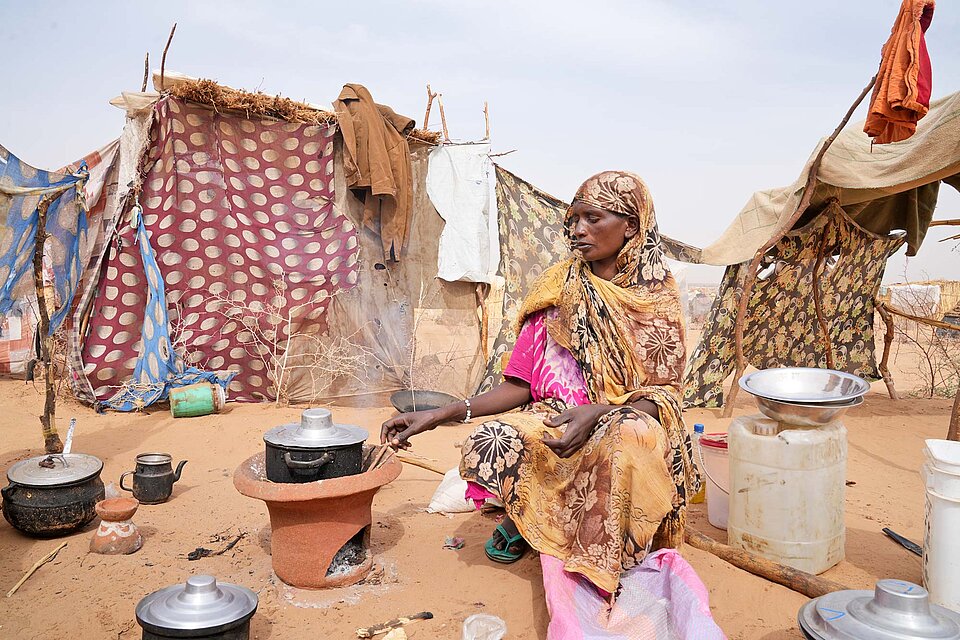 Konflikt im Sudan Frau beim Essenkochen im Freien