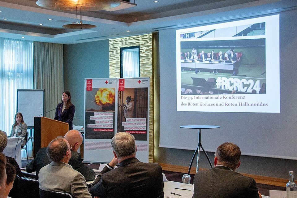 Referentin am Pult vor Präsentation