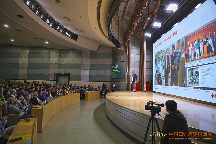 Referent auf Bühne vor Publikum