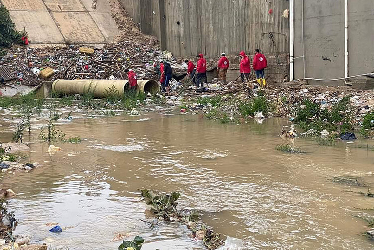 Sieben Hilfskräfte im Kniehohen Wasser nach Unwetter in Libyen