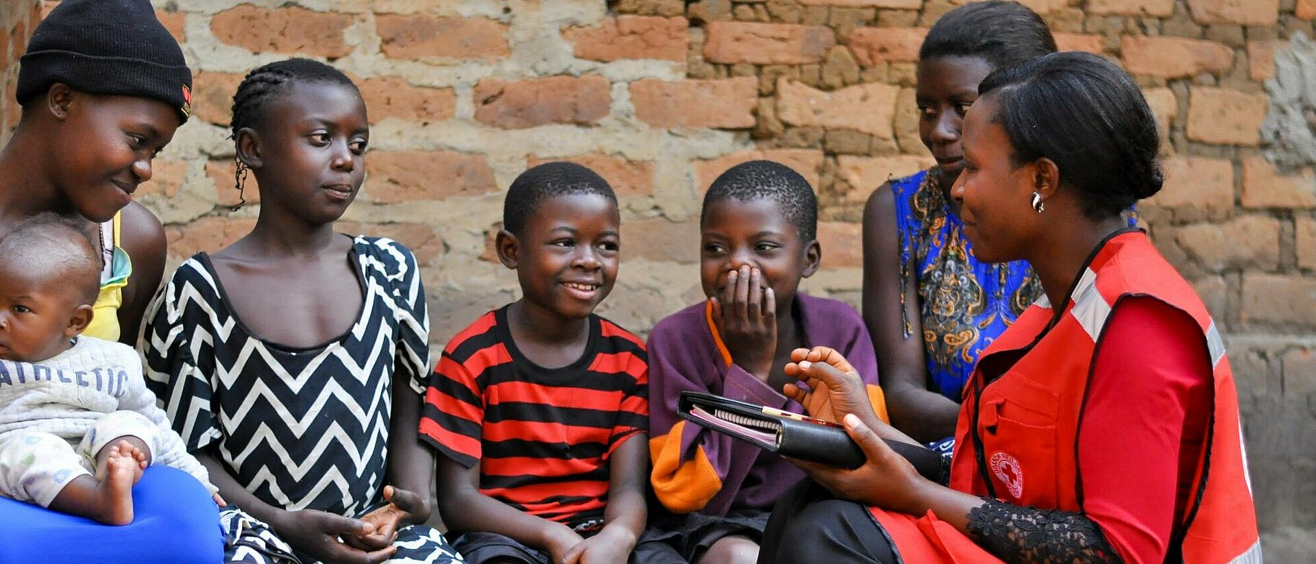 Kinder in Uganda mit Rotkreuz-Helferin 