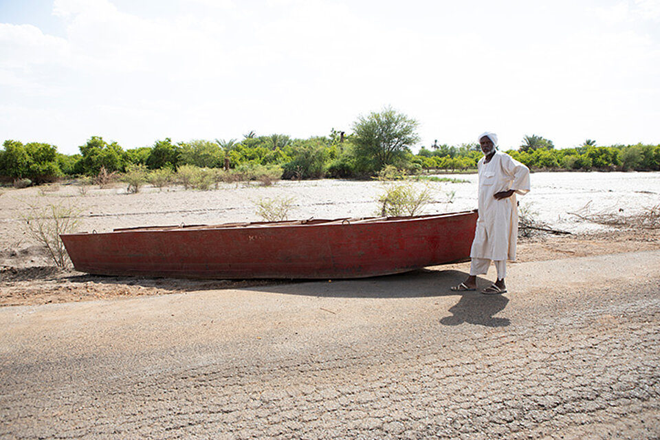 Sudanesischer Mann mit Boot am Fluss
