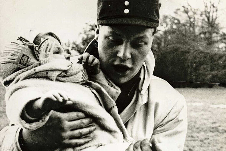 Der freiwillige Helfer Klaus-Peter Behrens mit der geretteten zweijährigen Ute Wilhelms in Hamburg (DRK)