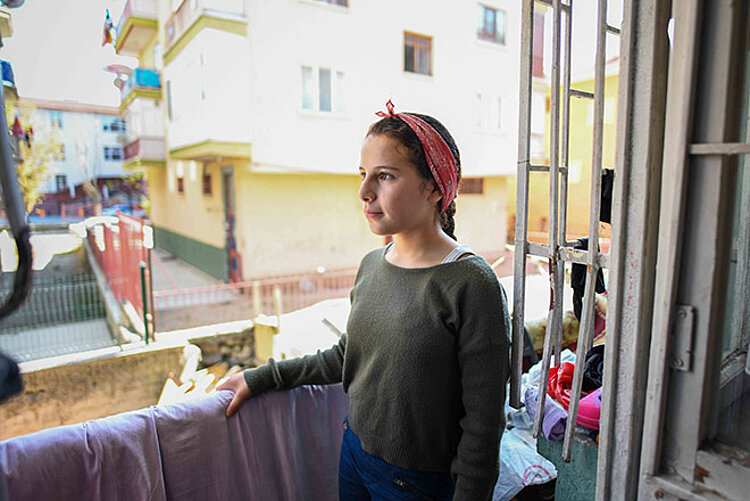 Mädchen aus Syrien an einem Fenster
