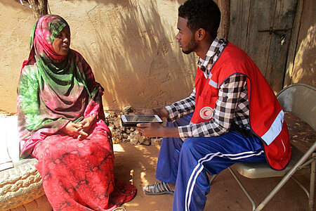 Foto: Somalische Frau im Gespräch mit einem Rothalbmondmitarbeiter