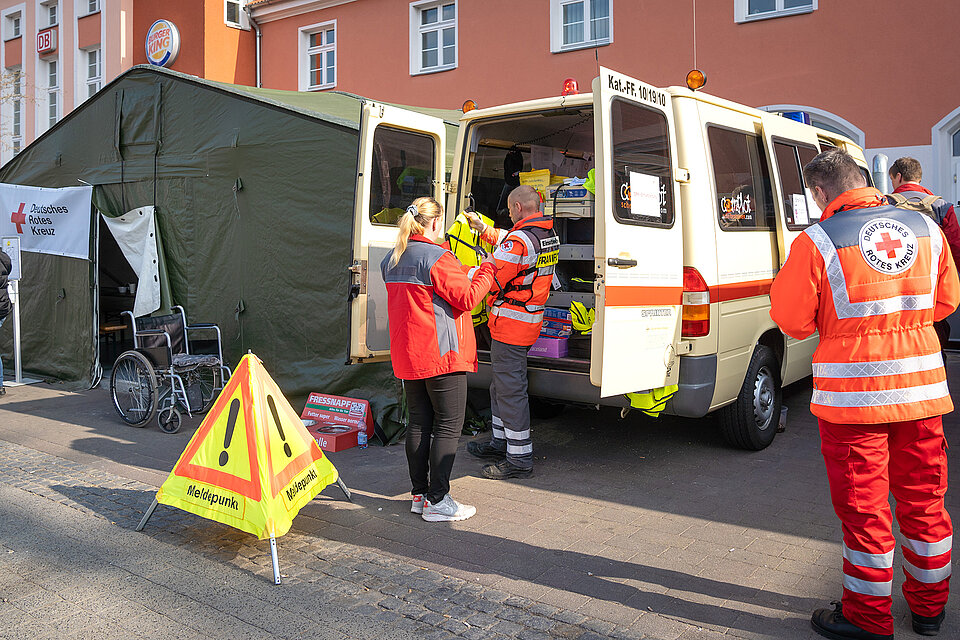 Helfer mit Einsatzfahrzeug am Meldepunkt vor Bahnhofsgebäude Frankfurt/Oder