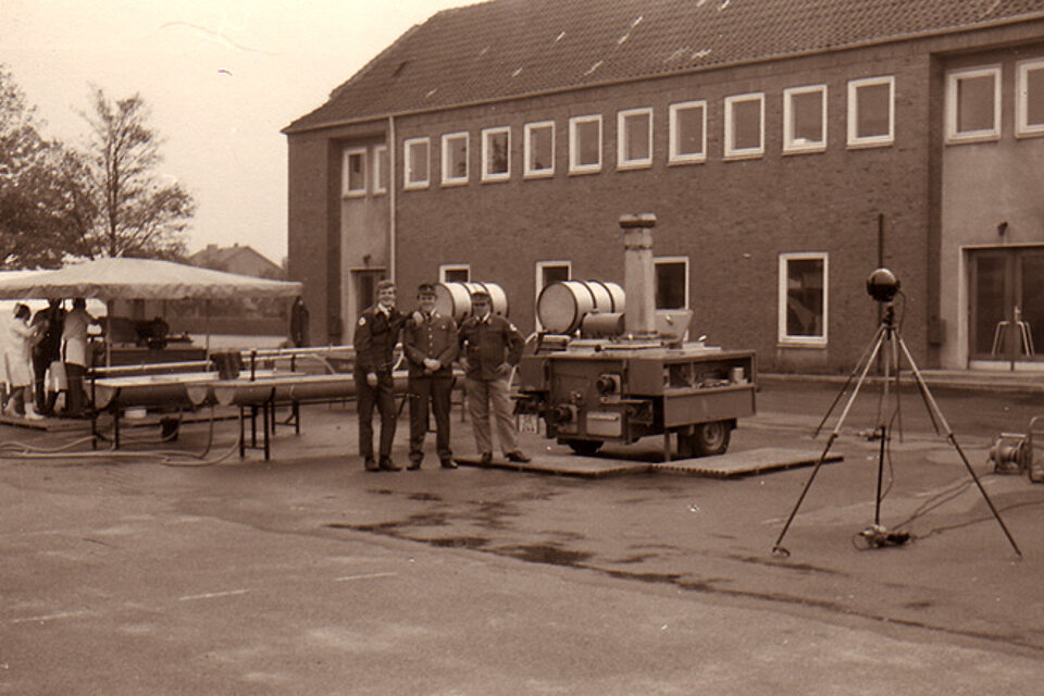 Rotkreuzler mit Küchenwagen und Pavillion vor Schule