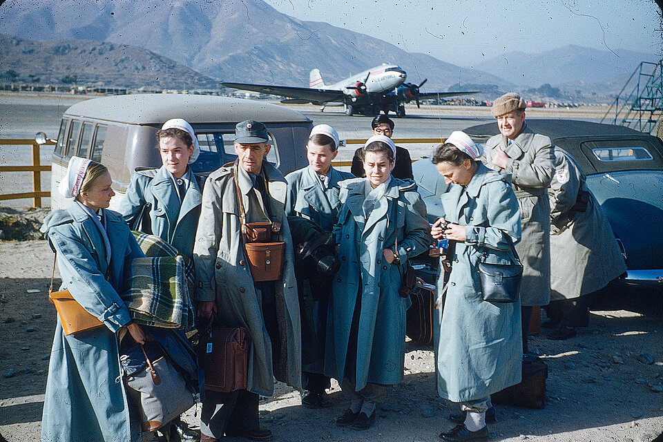 Krankenschwestern in Einsatzkleidung vor Flugzeug
