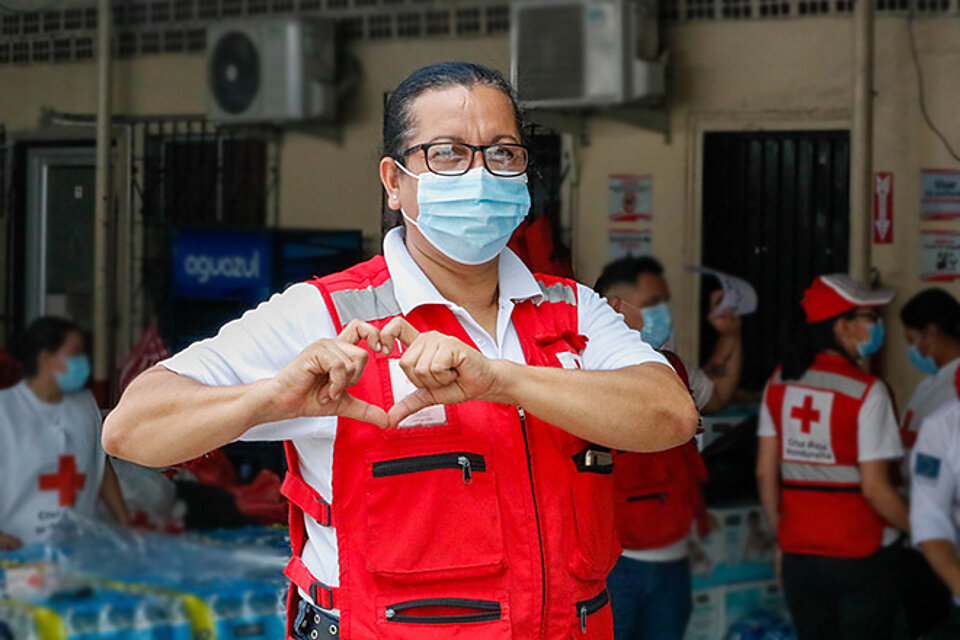 Rotkreuz-Helferin macht mit ihren Händen ein Herz