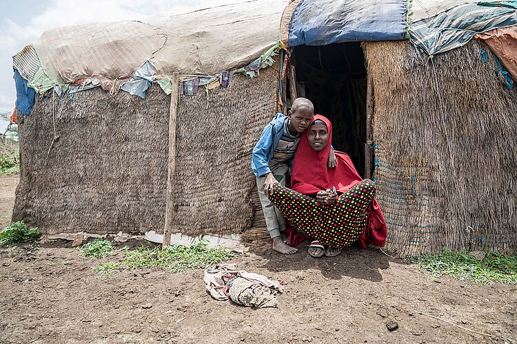 Äthiopierin mit Sohn vor Hütte aus Stroh und Decken