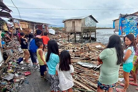 Menschen blicken auf Zerstörungen nach Taifun Rai auf den Philippinen