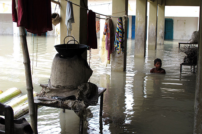 Ein Junge in einem überfluteten Dorf