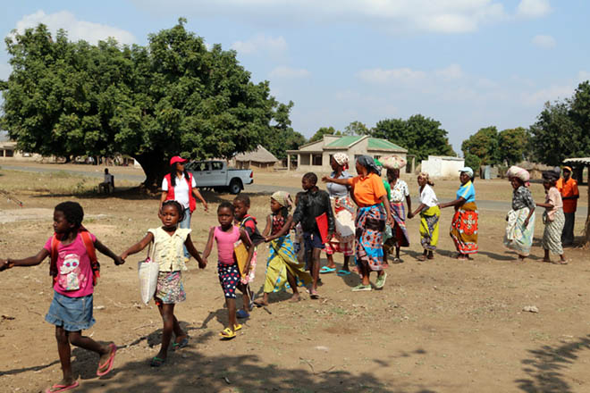 Foto: Kinder und Frauen in Mosambik laufen in einer Reihe.