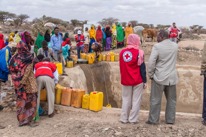 Somalier und Rotkreuzhelfer an der Wasserstelle
