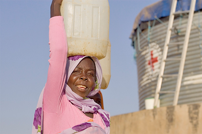 Sudanesin mit Wasserkanister auf dem Kopf