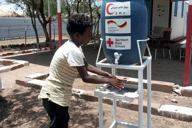 Junge im Sudan wäscht sich Hände an Handwaschstation