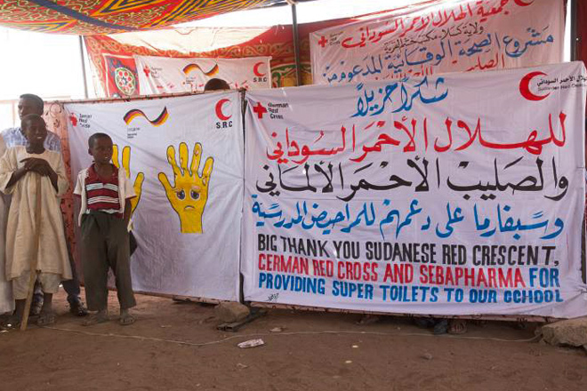 Foto: Dankesplakat mit Kindern davor (Sudan)