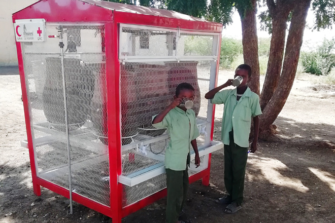 Foto: zwei sudanesischen Jungen an einer Trinkwasserstation