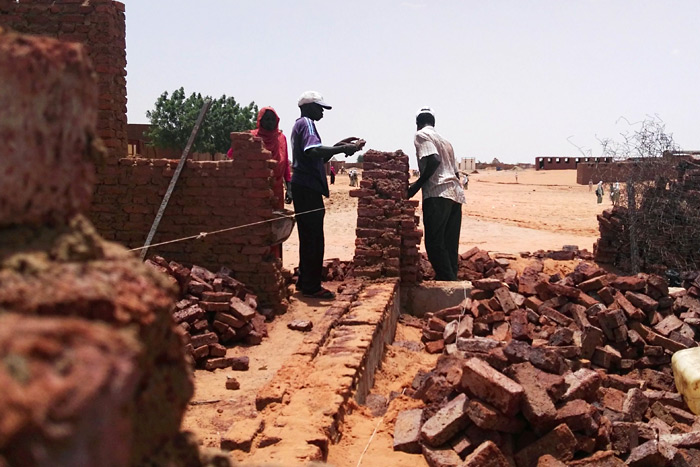 Foto: Zwei sudanesische Maurer mauern ein Gebäude