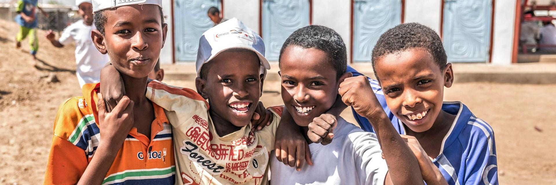 Foto: sudanesische Junge vor Latrinenblock