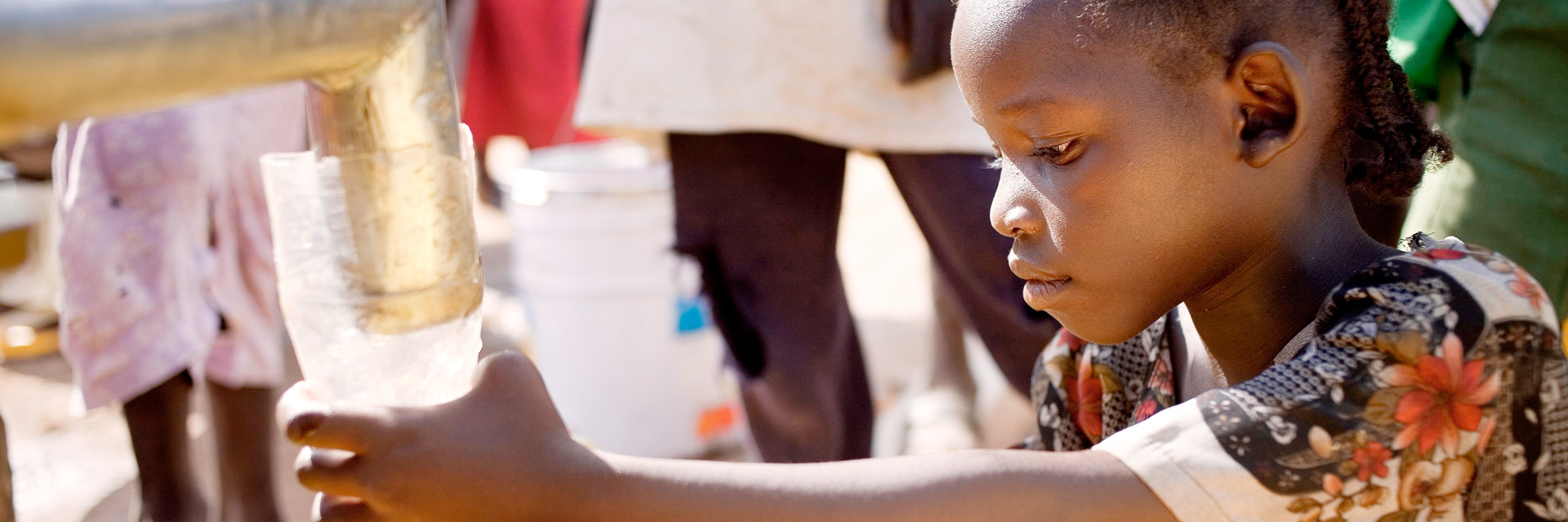 Foto: Ein sudanesisches Mädchen füllt Wasser in einen Kanister