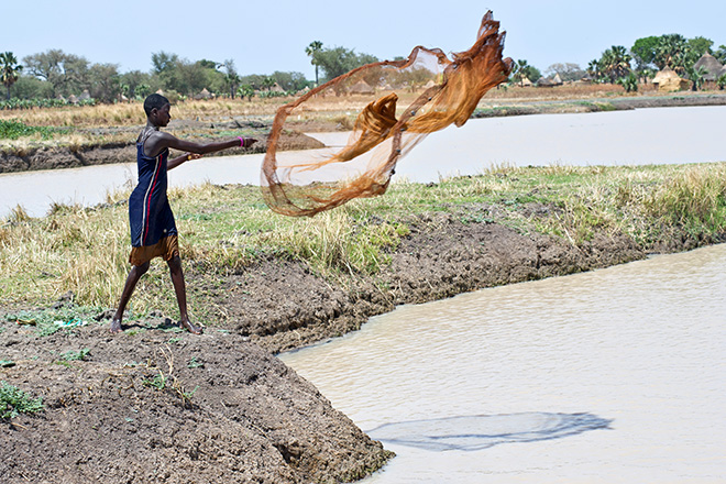 South Sudan women throws net into the water